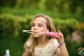 Girl blowing soap bubbles. Beautiful cheerful little girl play with bubbles