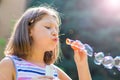 Girl blowing soap bubbles in park in a sunny day Royalty Free Stock Photo