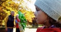 girl blowing toy with parents in background