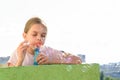 Girl blows bubbles on the balcony of a high-rise building