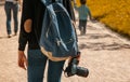 Girl with a blue backpack and a camera in hand. Traveling the world.