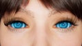 A girl with blue cyber eyes looks into the camera close-up. Macro shot of blue cyber eyes. The girl is made using Royalty Free Stock Photo