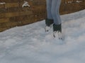 Girl in jeans and wellington boots standing in deep snow