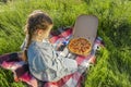 Krivoy Rog, Ukraine, May 1, 2024: Girl with pizza and Pepsi Cola on green grass