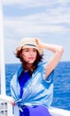 Girl in blue dress and hat have a voyage on a boat Royalty Free Stock Photo