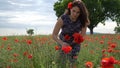 Girl in a blue dress at a poppy flower garden