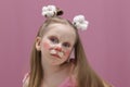 A girl with blue eyes and children\'s makeup. A child with a funny face painting. Makeup of a rabbit on the face of a child. Royalty Free Stock Photo