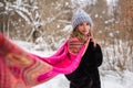 girl in a blue hat, black fur coat and fluttering pink flying scarf among the snowy forest Royalty Free Stock Photo