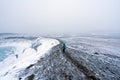 Girl with blue jacket hikes above ice covered Viti volcanic crater near Krafla geothermal area in Iceland. Royalty Free Stock Photo