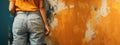 Girl in blue jeans facing an orange wall with messy brush strokes texture. Renovations, painting. Generative AI Royalty Free Stock Photo