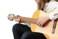 A girl in blue jeans and a white shirt plays the guitar