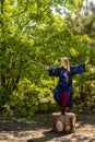 A woman in a blue kimono poses with a sword in the forest standing on a stump Royalty Free Stock Photo