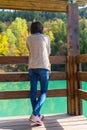 A girl by a blue mountain lake with a house. Beautiful autumn morning Royalty Free Stock Photo