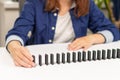 A girl in a blue shirt plays dominoes at home on a white wooden table Royalty Free Stock Photo