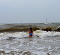 A girl in a blue swimsuit on the yellow sea