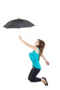 Girl in blue t-shirt and black tights with umbrella jumping Royalty Free Stock Photo