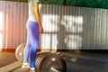 A girl in a blue T-shirt and tights stands in an open gym in fro