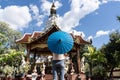 Girl with a blue umbrella in front of a Buddhist temple Royalty Free Stock Photo