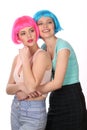 Girl in blue wig hugging her friend. Close up. White background