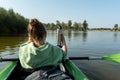 The girl in the boat holds a thermos for tea. Rafting down the river with a thermos Royalty Free Stock Photo