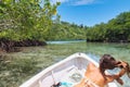 Girl on a boat plaiyng with wet hair in a bay of mangroves Royalty Free Stock Photo