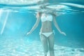 Girl body swimming underwater portrait. Sea summer blue water background with bubbles sunny ray of lights