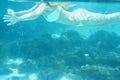 Girl body swimming underwater portrait. Sea summer blue water background with bubbles sunny ray of lights