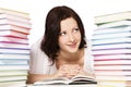 Girl between books stacks reading. Royalty Free Stock Photo