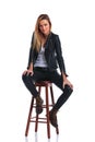 girl in boots and leather jacket pose seated in white studio background Royalty Free Stock Photo