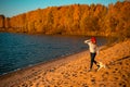 Girl with border collie dog on beach at seaside. autumn yellow forest on background Royalty Free Stock Photo