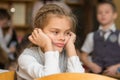 Girl bored at school sitting at a desk on reverse