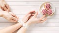 A girl with bound hands measuring tape reaches for a delicious sweetness.male hands holding a measuring tape without letting it