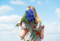 The girl with a bouquet of cornflowers on sky background. Royalty Free Stock Photo