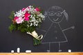 Girl with bouquet of flowers on blackboard teacher day abstract concept