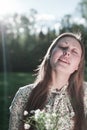 Girl with a bouquet of flowers and with her eyes closed