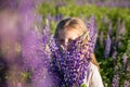 Girl with a bouquet in the hands.portrait of cute little happy seven year old kid girl with bloom flowers lupines in Royalty Free Stock Photo