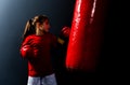 A girl in boxing gloves hits a punching bag