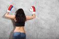 Girl in boxing gloves leaned to wall