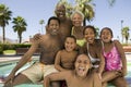 Girl (5-6) boy (7-9) boy (10-12) with parents and grandparents at swimming pool front view portrait. Royalty Free Stock Photo