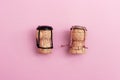 Girl and boy characters from champagne corks and muselets together on pink colored background Royalty Free Stock Photo