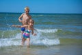 Girl and boy of having fun in water on beach and splashing Royalty Free Stock Photo