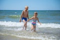 Girl and boy of having fun in water on beach and splashing Royalty Free Stock Photo
