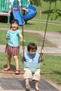 Girl & boy at the park swinging