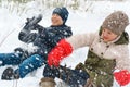 A girl and a boy are playing snowballs outside, beautiful winter weather and white snow around Royalty Free Stock Photo