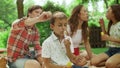 Girl and boy playing with soap bubbles in park. Family having picnic in forest Royalty Free Stock Photo