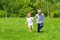 Girl and boy running on the grass Royalty Free Stock Photo