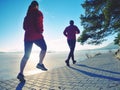 Girl and boy running while sun makes reflections in frozen lake surface. Royalty Free Stock Photo