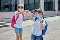 A girl and a boy in the school yard. A girl hits a schoolboy on the head with a notebook. Bullying in schools