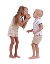 Girl and boy sharing a cinnamon bun isolated on a white background. Children eating a bun. Pastry production concept. Royalty Free Stock Photo