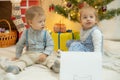 Girl and boy sit against a christmas tree and fireplace near a white sheet of paper Royalty Free Stock Photo